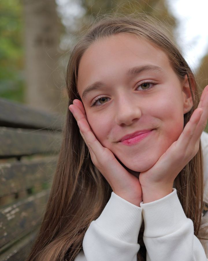 Thya souriante, accoudée à un banc